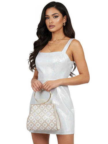 Woman wearing a white dress holding a patterned handbag on a white background